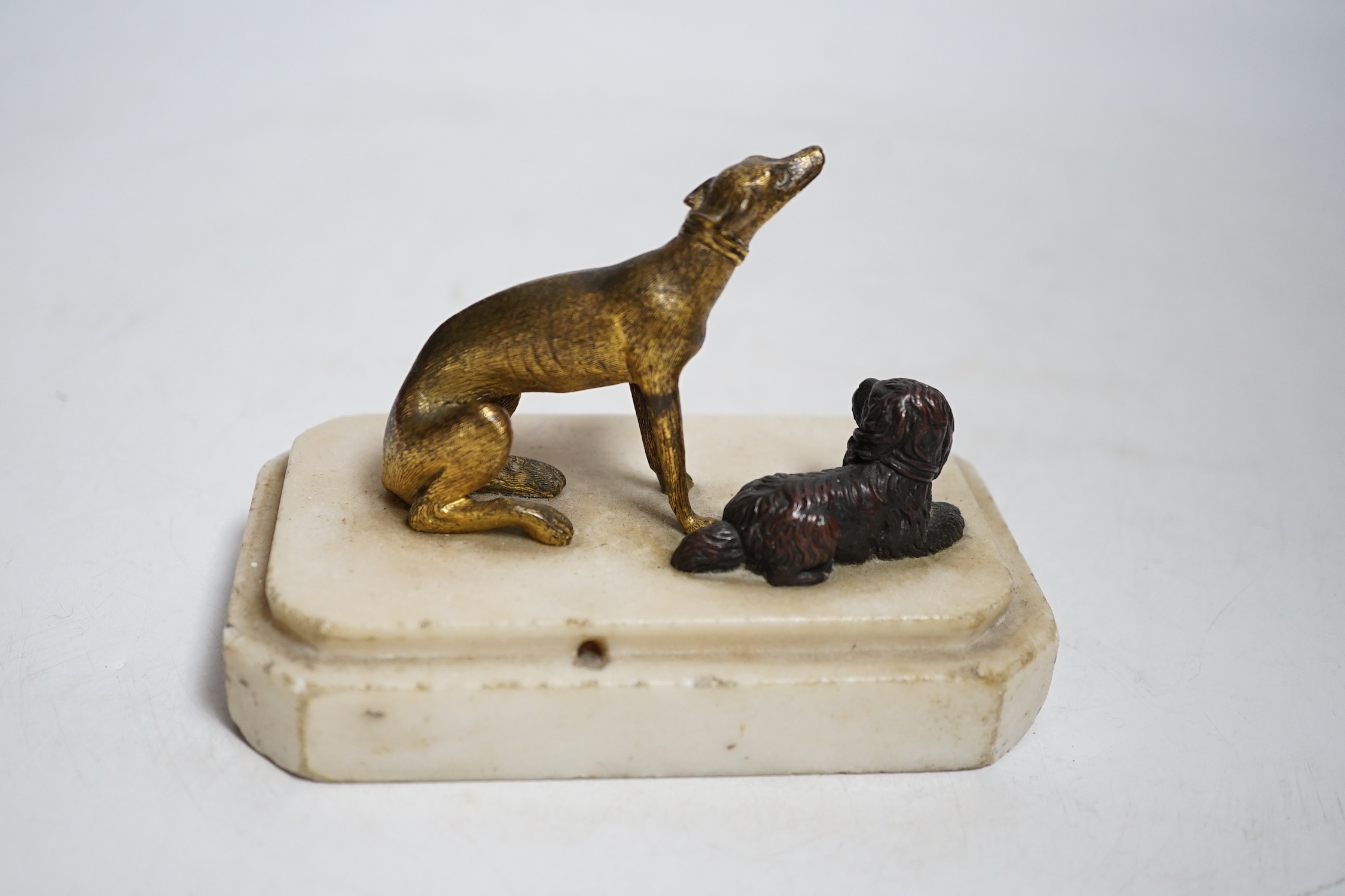 A 19th century group of two bronze dogs on a mounted marble base, 8.5cm tall